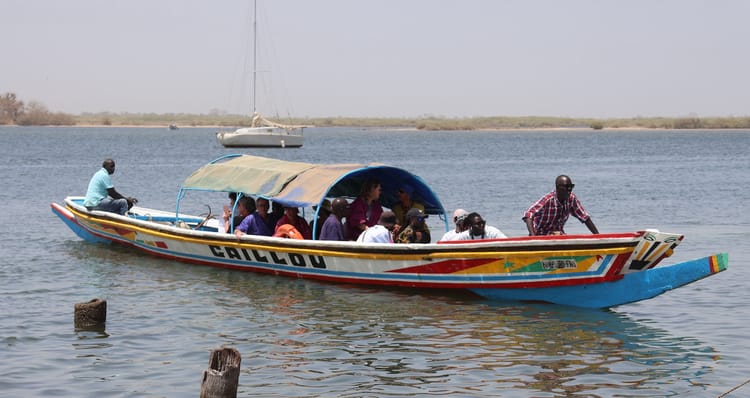 Pirogue colorée pleine de passagers sur le fleuve Saloum au Sénégal