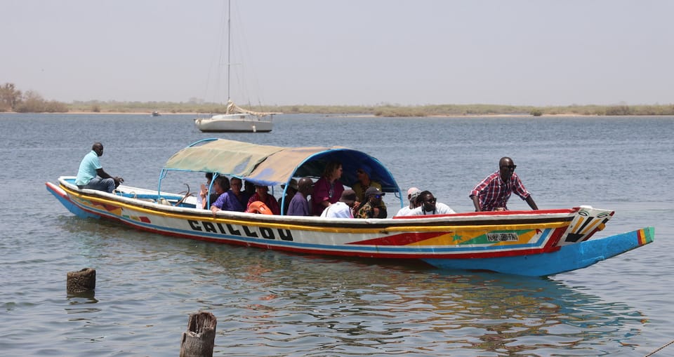 Pirogue colorée pleine de passagers sur le fleuve Saloum au Sénégal